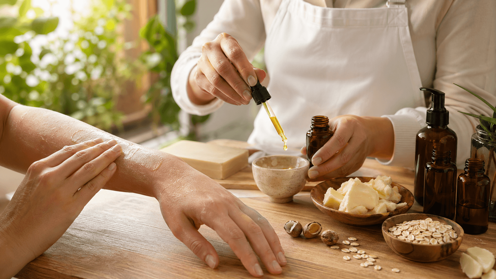 Amber glass dropper bottle and small bowl of oil on a neutral countertop, softly lit with beige linen nearby