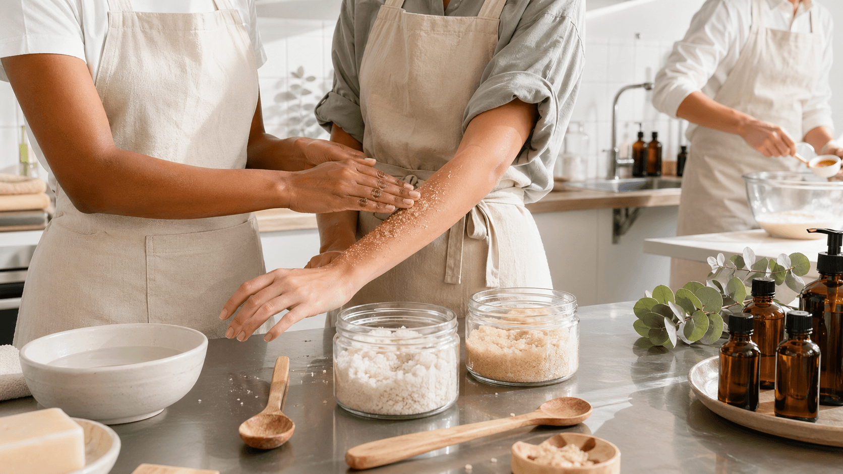 Open jar of body scrub with a wooden spoon on a white countertop, surrounded by sea salt and citrus slices.
